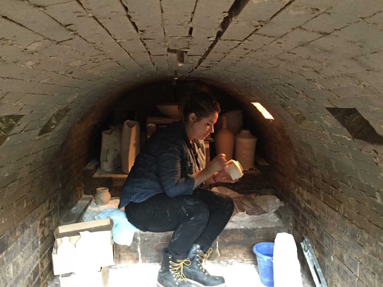 Jacklyn Scott helps load Muller's kiln. 