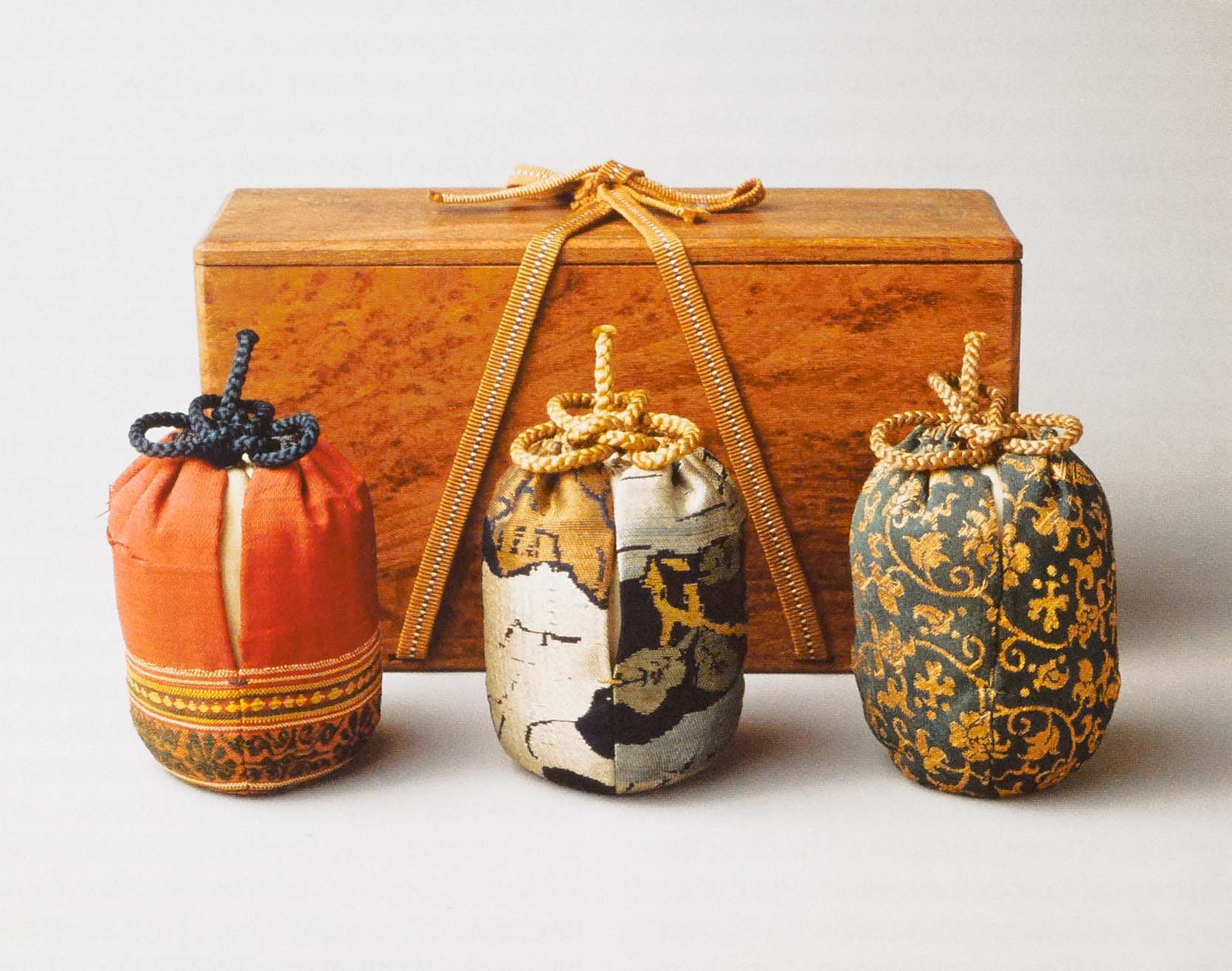 The three silk display bags with their box. Left: the informal bag of Satsuma Canton (Indian silk); center: the formal bag of Kiyomizu fragment (Chinese silk); right: the intermediate bag of gold brocade (Chinese silk).