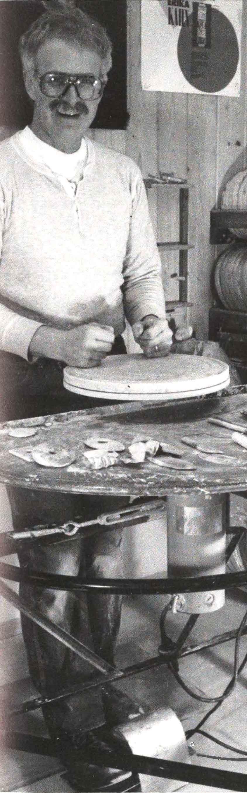 John Glick at his potter's wheel, raised to enable throwing pots standing, rather than sitting, for back health.