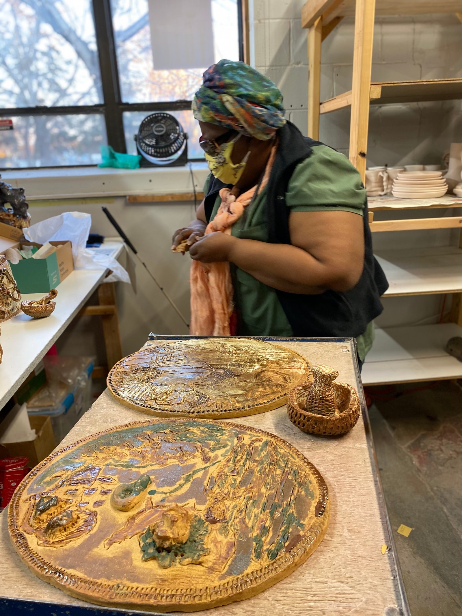 Donna Ray working on her cameos in the studio. Each cameo is made of rake clay and are sixteen by twenty inches. Photo courtesy of Northern Clay Center.