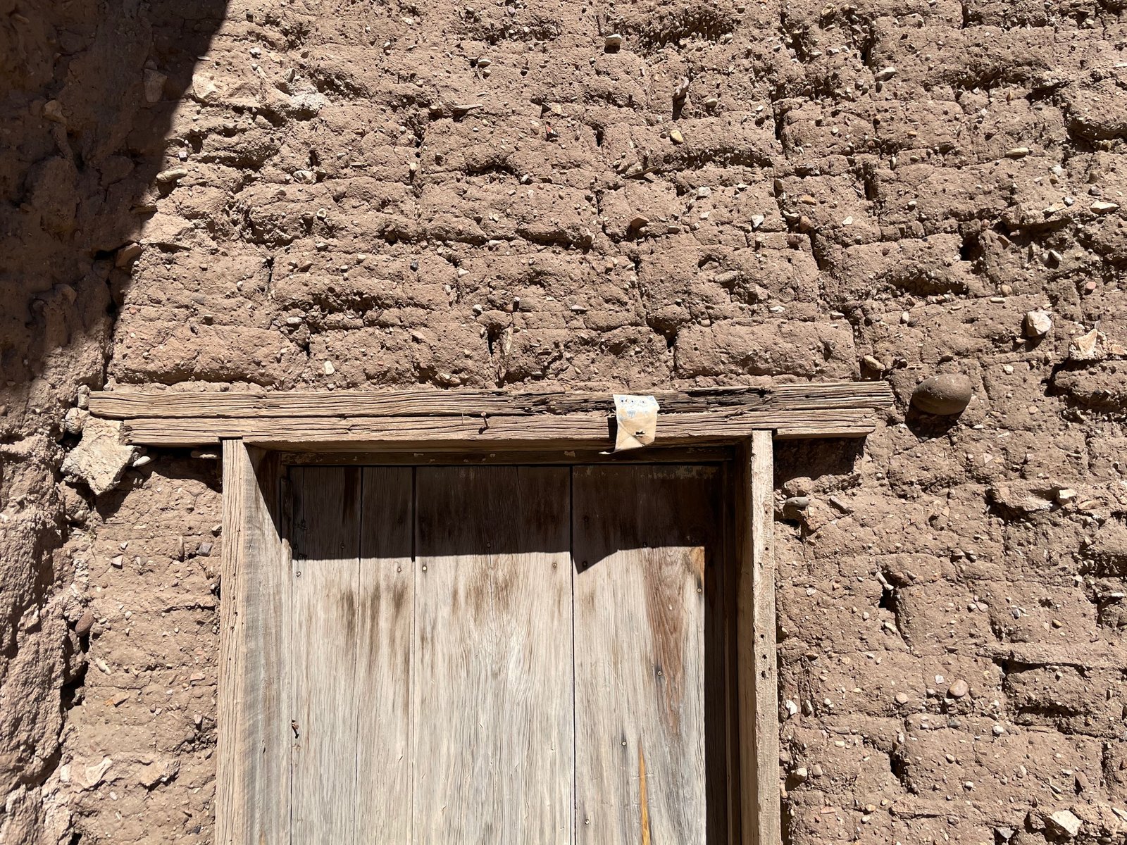 Detail of adobe construction from the early 1900s. Doorway into Centro Cultural Santa Rosa Casa De Barro. On the upper right corner of the door there is a