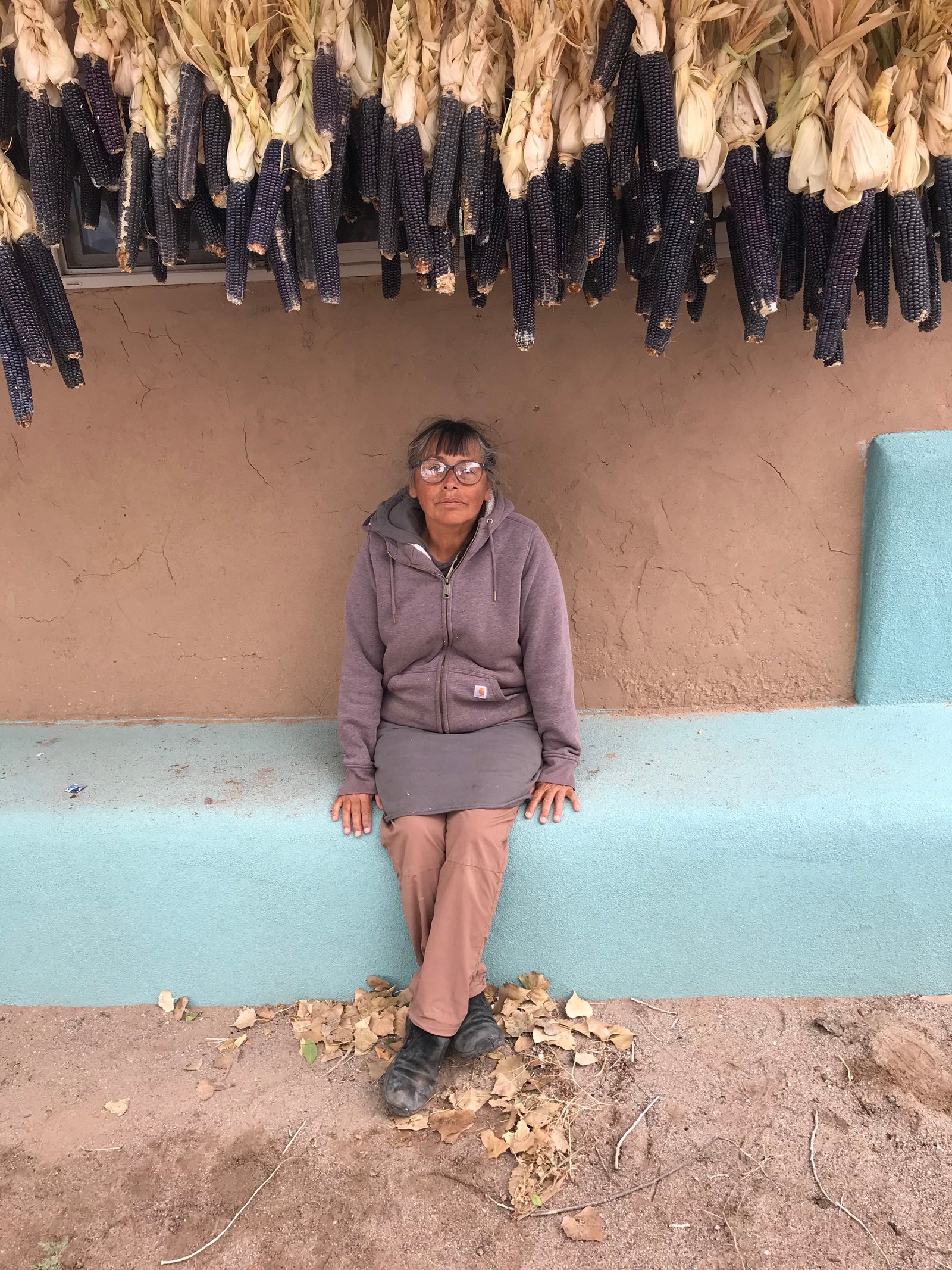 Roxanne sits at the Women’s House she built under corn she helped grow. Located in Santa Clara Pueblo, the Women's House was established in 2017 as a space for women to gather for many tribal functions including to learn traditional bread making known as buwah.