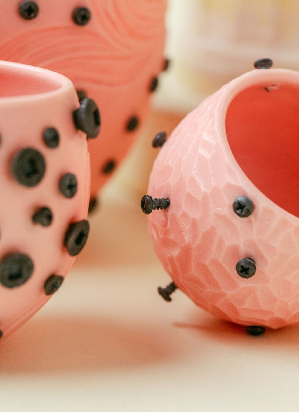 Detail image of screws embedded into colored porcelain from series “Resilient”, cone 6 colored porcelain with embedded stainless steel screws. Photo courtesy of Ty and Chey.