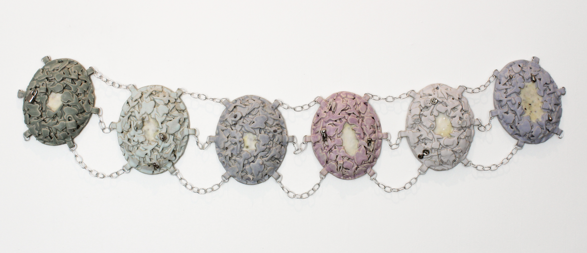 Abbey Peters, Heirloom: To Hide and To Hold, 2025, ceramic, glaze, luster, wire, beeswax, abortifacient herbs, birth control and morning-after pills, 3" x 16" x 72" Abbey Peters, Heirloom: To Hide and To Hold, 2025, ceramic, glaze, luster, wire, beeswax, abortifacient herbs, birth control and morning-after pills, 3" x 16" x 72"
