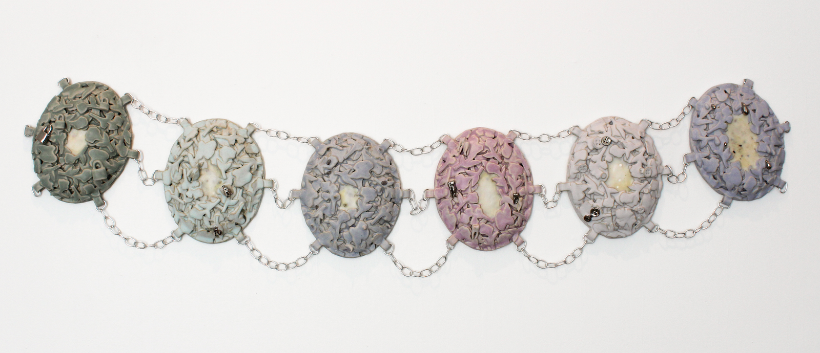 Abbey Peters, Heirloom: To Hide and To Hold, 2025, ceramic, glaze, luster, wire, beeswax, abortifacient herbs, birth control and morning-after pills, 3" x 16" x 72" Abbey Peters, Heirloom: To Hide and To Hold, 2025, ceramic, glaze, luster, wire, beeswax, abortifacient herbs, birth control and morning-after pills, 3" x 16" x 72"